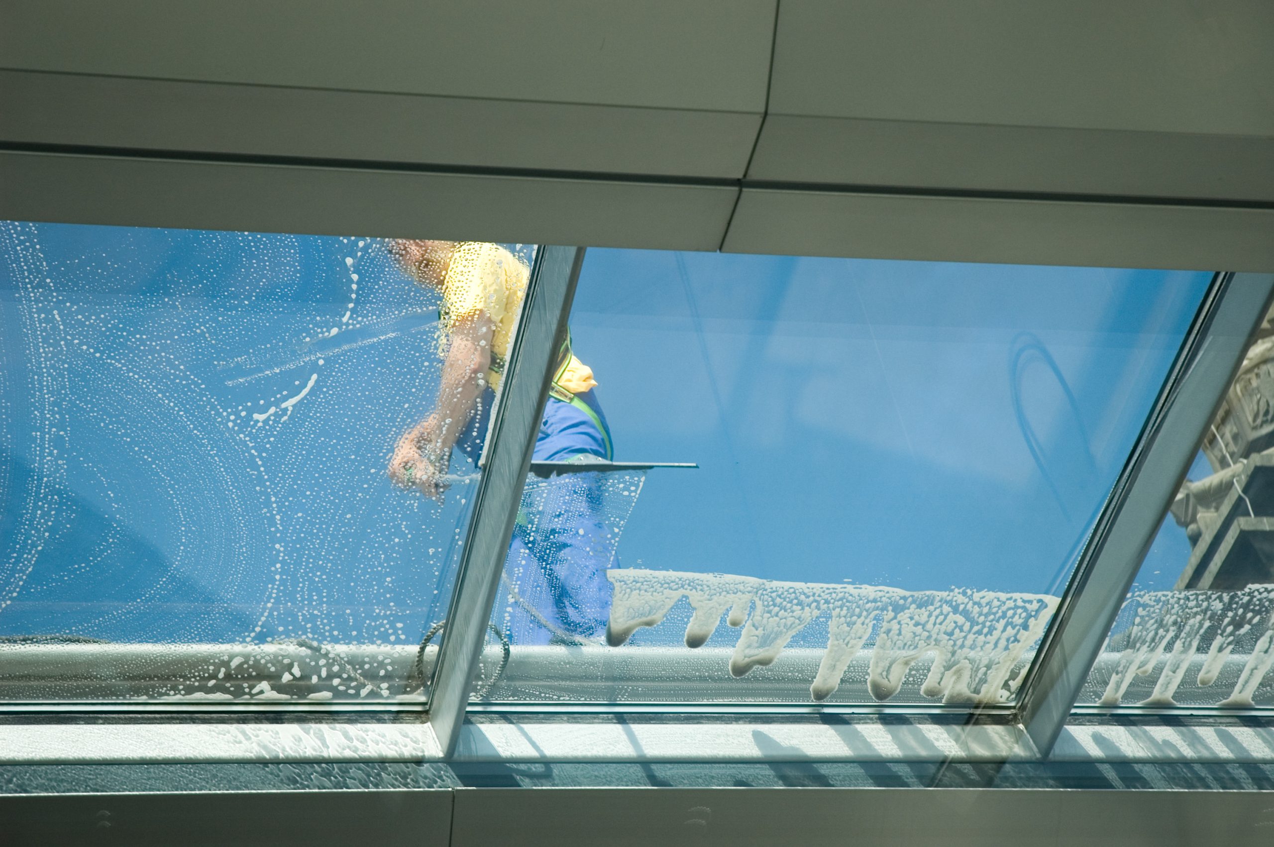 Fensterreiniger säubert Glasdach mit Abzieher